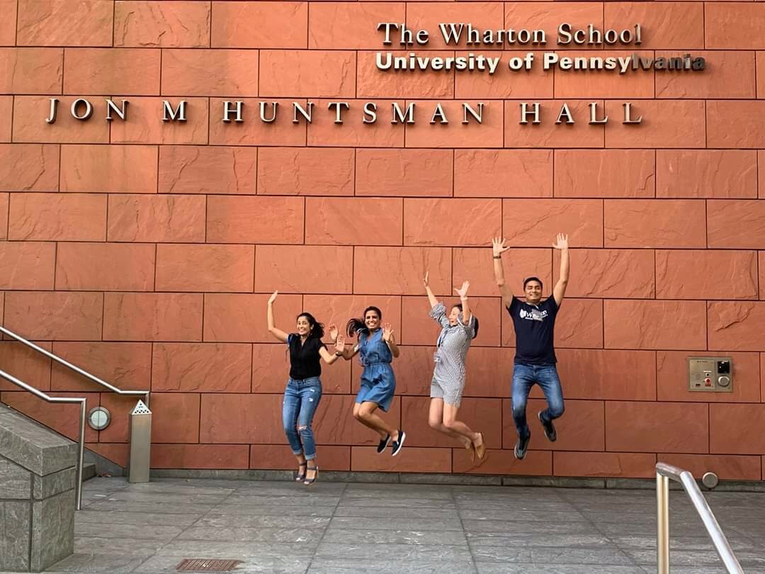 Students cheering under Wharton signage